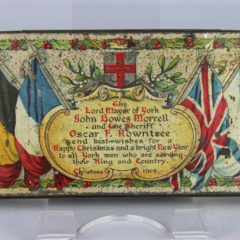 A decorative tin with a message from the Lord Mayor of York and The Sheriff printed on it.